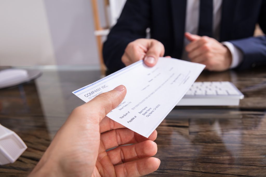 businessperson's hand giving check